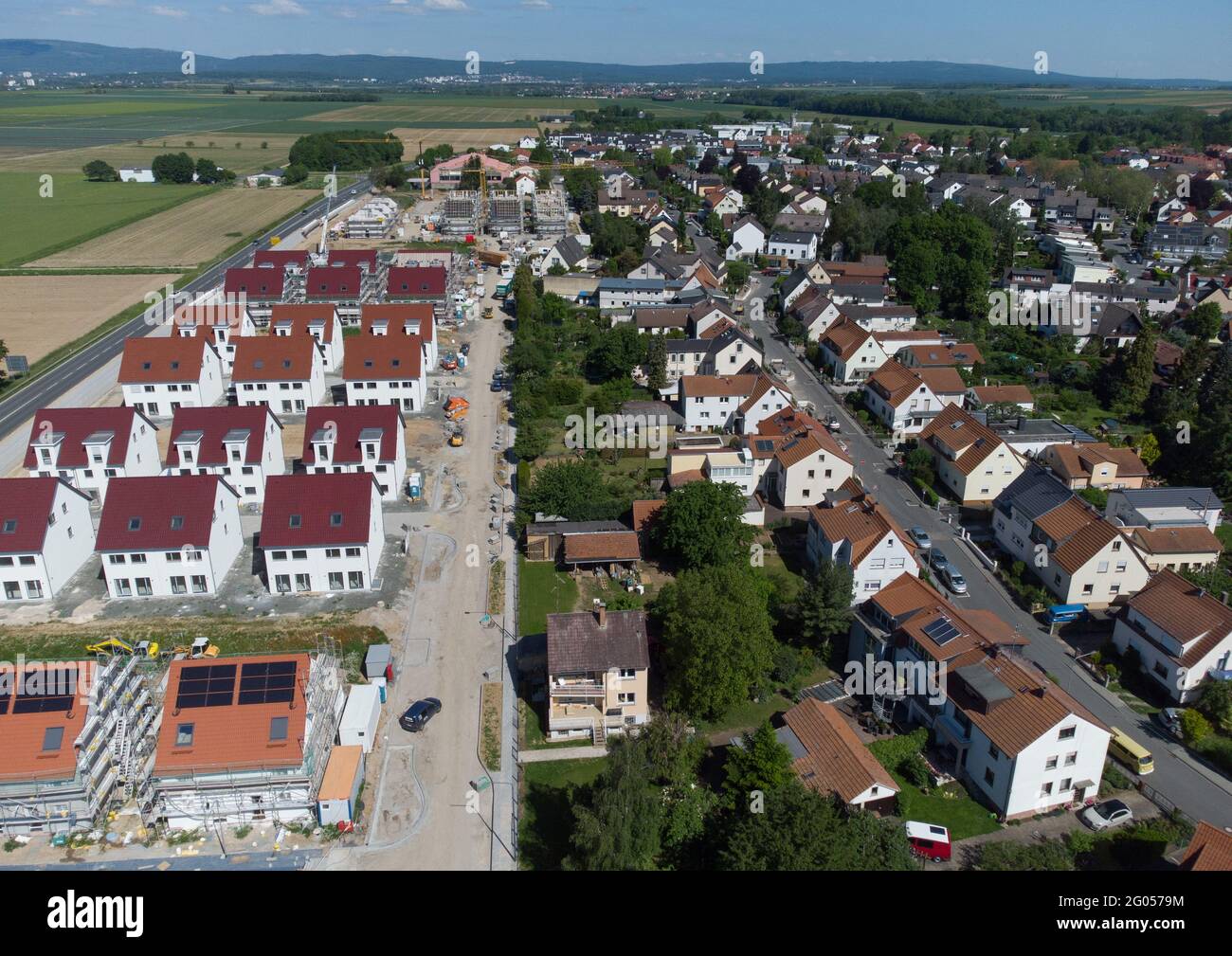 Nieder Erlenbach, Germany. 31st May, 2021. Only a road separates the new housing estate in the Frankfurt district of Nieder-Erlenbach from the farmland, while the Taunus Mountains can be seen in the background (aerial photograph taken with a drone). Experts are critical of the development of grassland in Hesse. (to dpa "Land consumption in Hesse") Credit: Boris Roessler/dpa/Alamy Live News Stock Photo