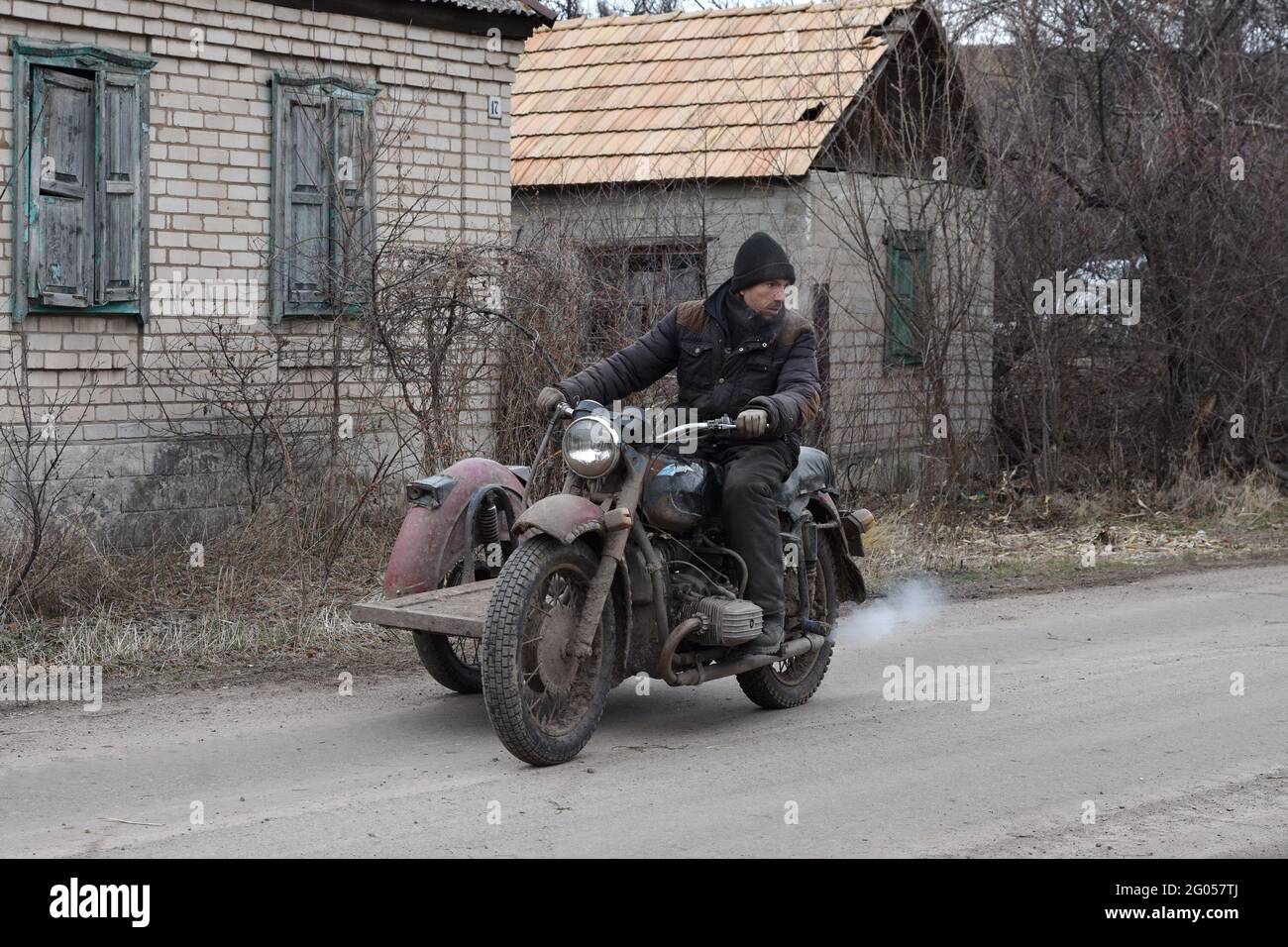 February 7 2021 Zaitsevo Donetskaya Region Ukraine A Man Rides A Soviet Motorcycle For Firewood To Heat The Stove In The House At The Village Of Zaitsevo The Military Conflict Has Been Going