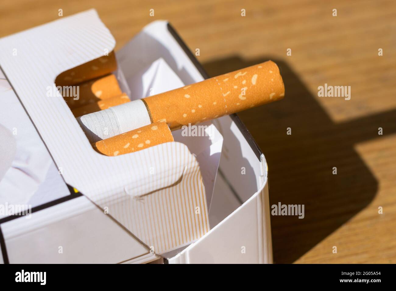 Open pack of cigarettes on old wooden table.Closeup pile cigarettes on ...