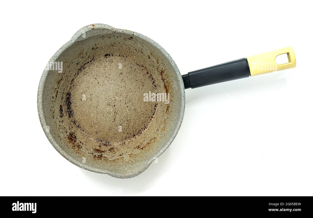 Top view small modern saucepan with burning mark on the surface, modern pan with black handle, the image on white background. Stock Photo