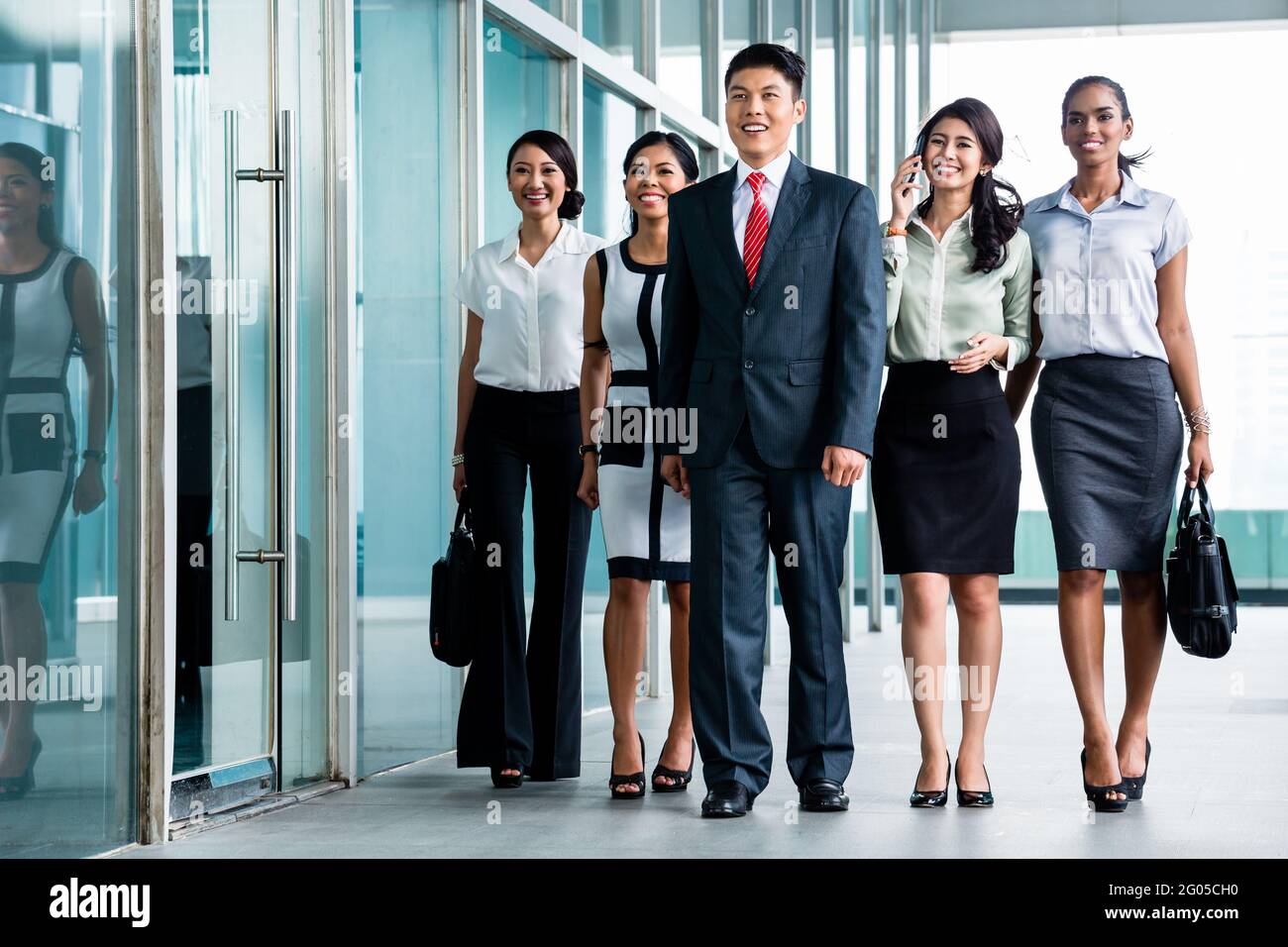 Asian business team of executives walking into office very determined to find some fault in the books they will do revision in Stock Photo
