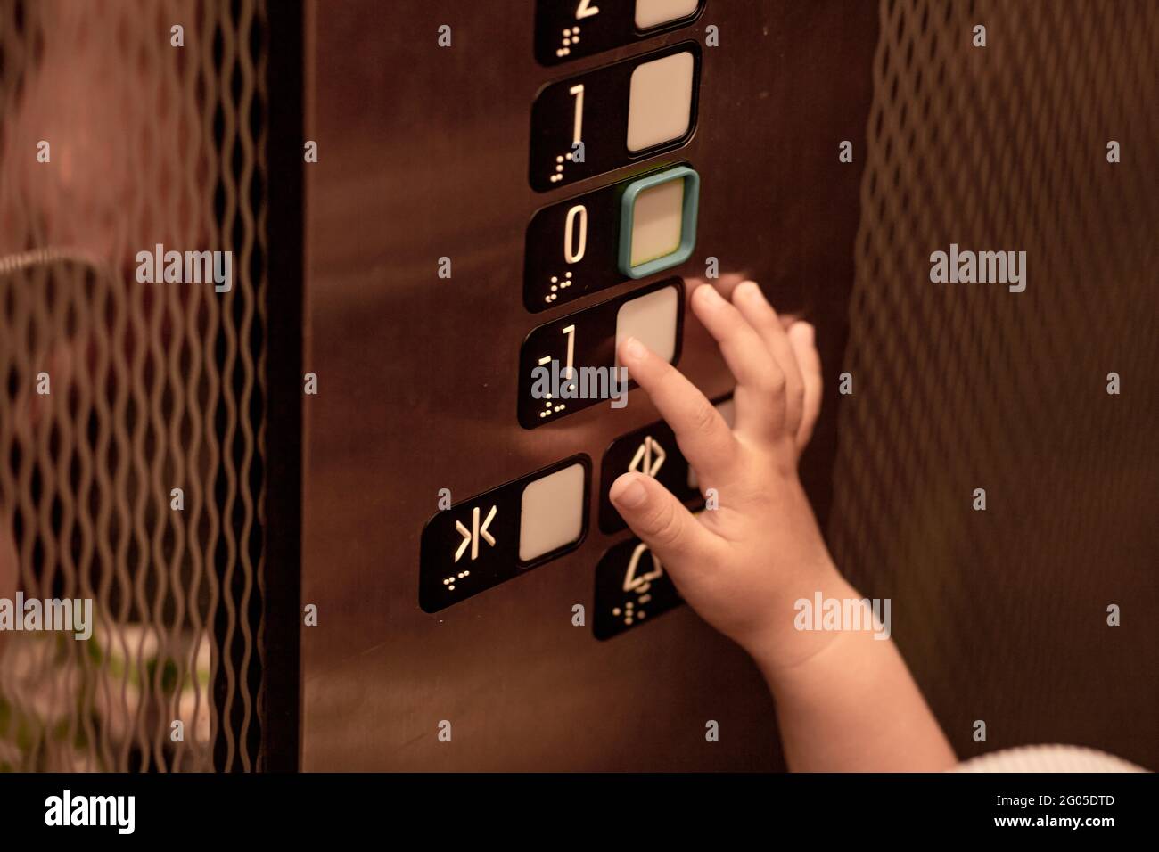 Child is curious and presses the elevator button. The concept of germs hit and insecurity. High quality photo Stock Photo