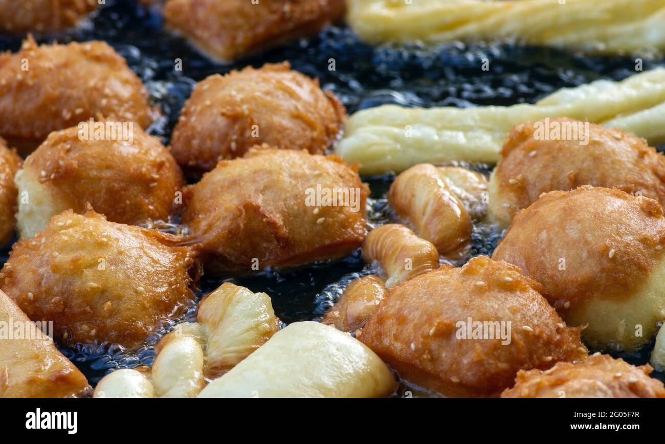 Frying cakwe or cakue in hot oil, a popular traditional snack from Asia, delicious street foods, selected focus. Stock Photo
