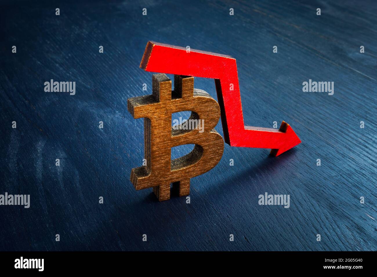 Bitcoin sign and falling arrow. The crisis and the decline in the price of cryptocurrency. Stock Photo