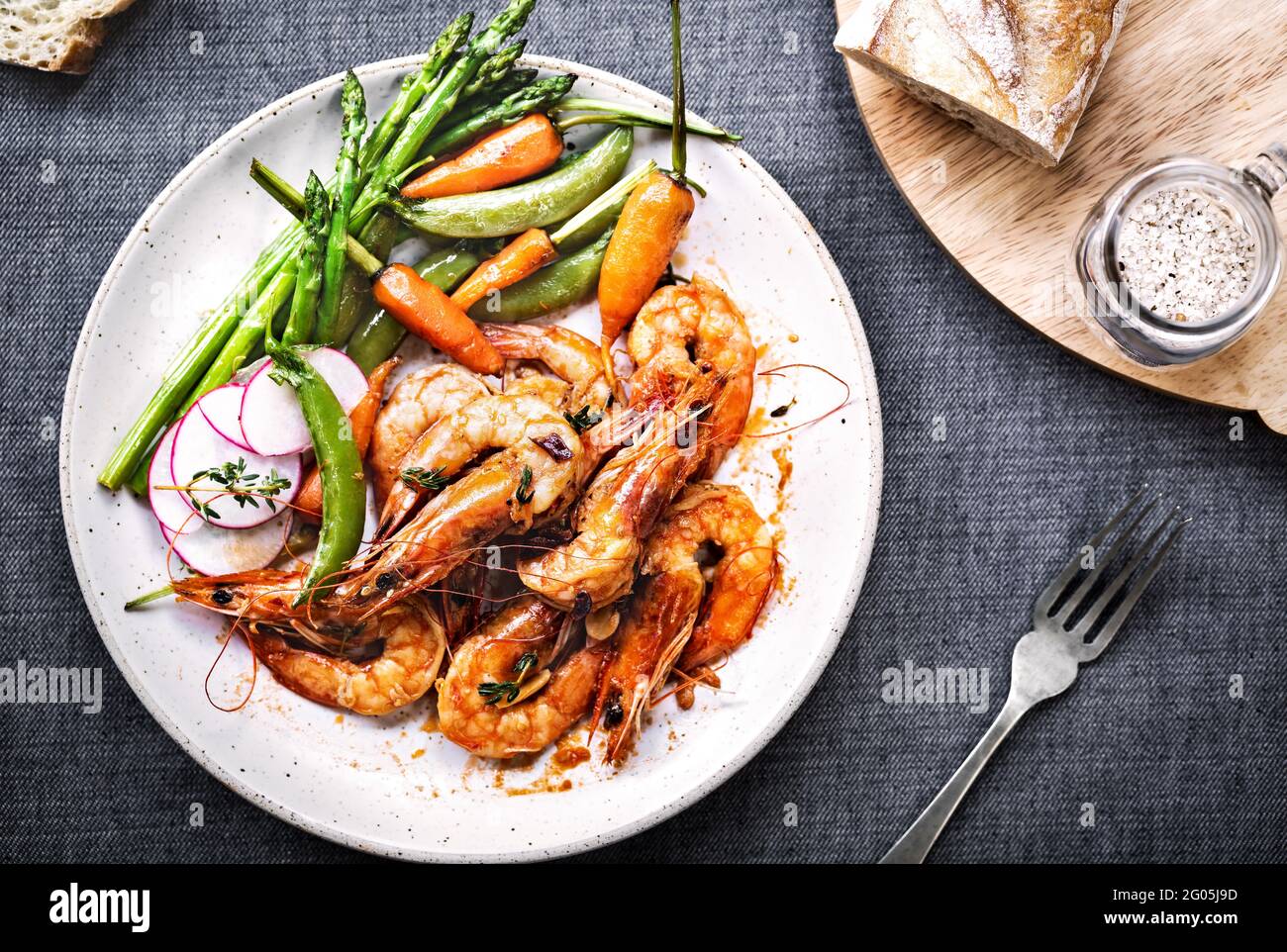 Garlic and Herby Prawn with Sauteed Asparagus, Baby Carrot and Snap pea Stock Photo