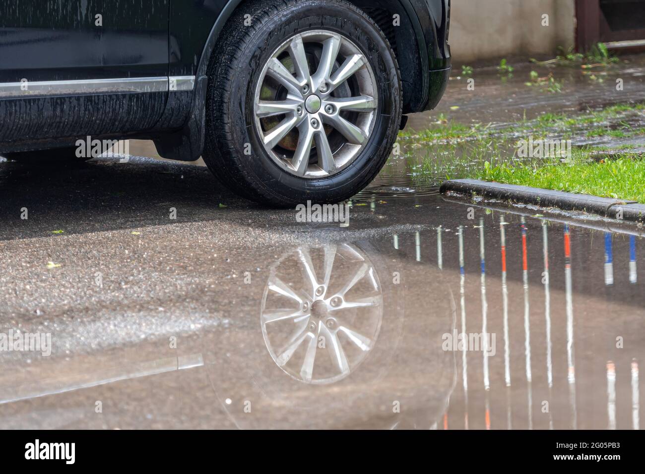 puddle on the pavement with a reflection of the car wheel, close-up ...