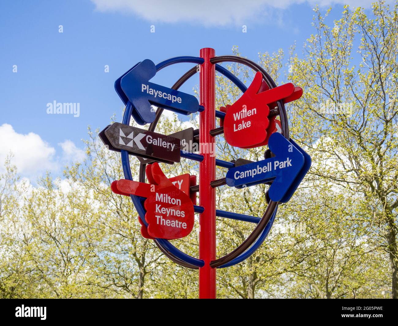 Colourful circular metal signpost giving directions to various ...