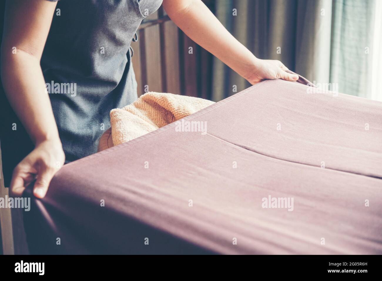 House Cleaner prepare bed sheet in Luxury Hotel. Chambermaid housework