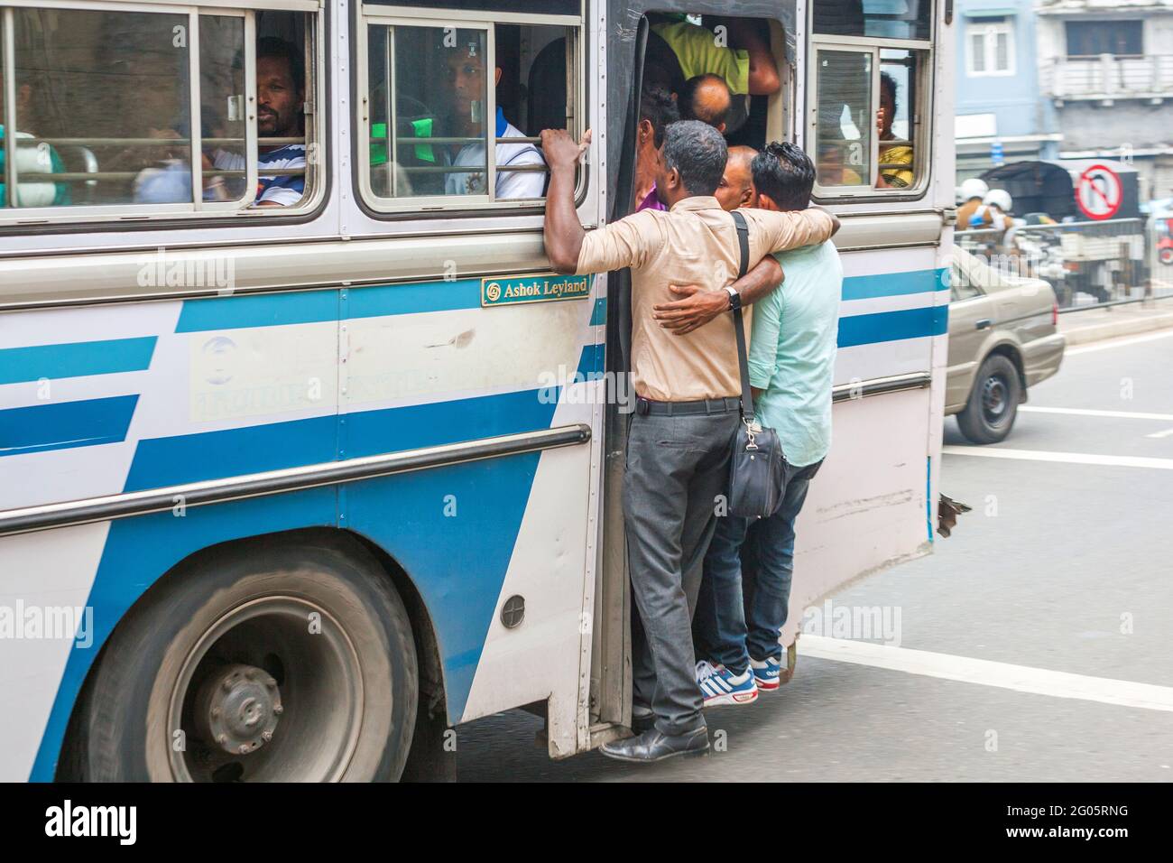 Sri Lankan bus passengers jammed into doorway entrance of single decker