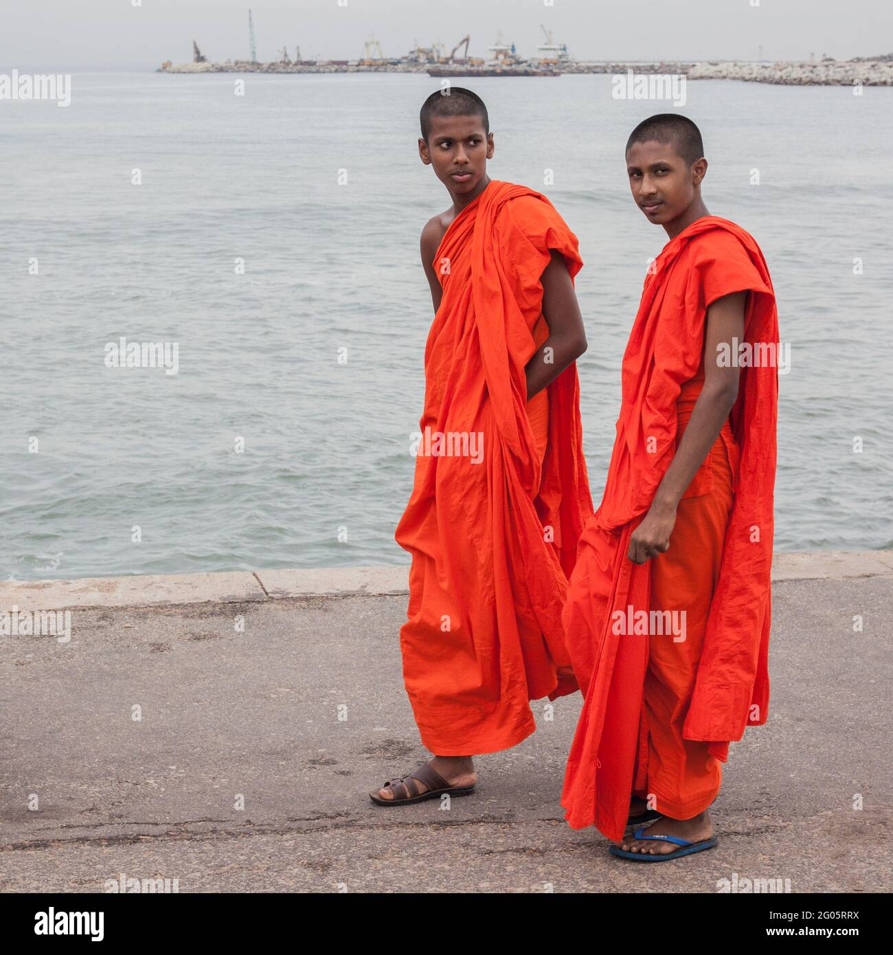 Two young Buddhist monks pose for photo as they walk along Galle Face, Colombo, Sri Lanka Stock Photo