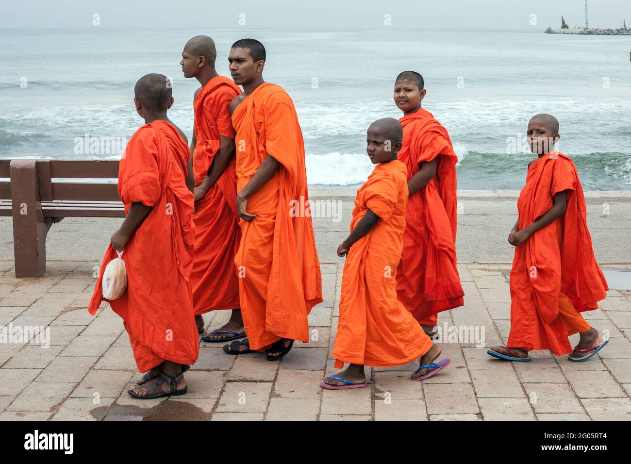 Group of Buddhist monks of various ages preamble along Galle Face, Colombo, Sri Lanka Stock Photo