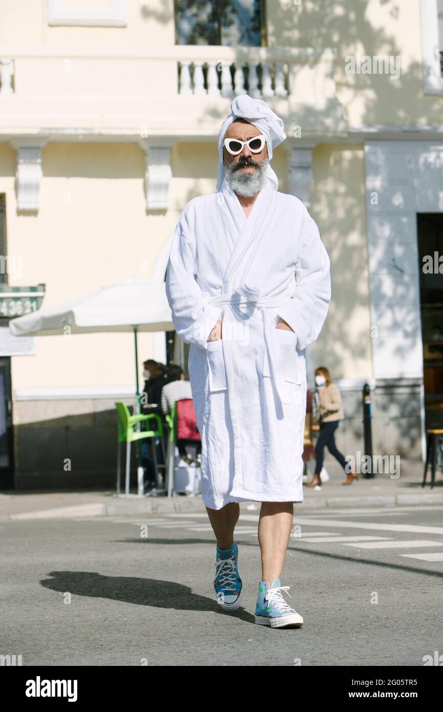 man in bathrobe crossing the street Stock Photo