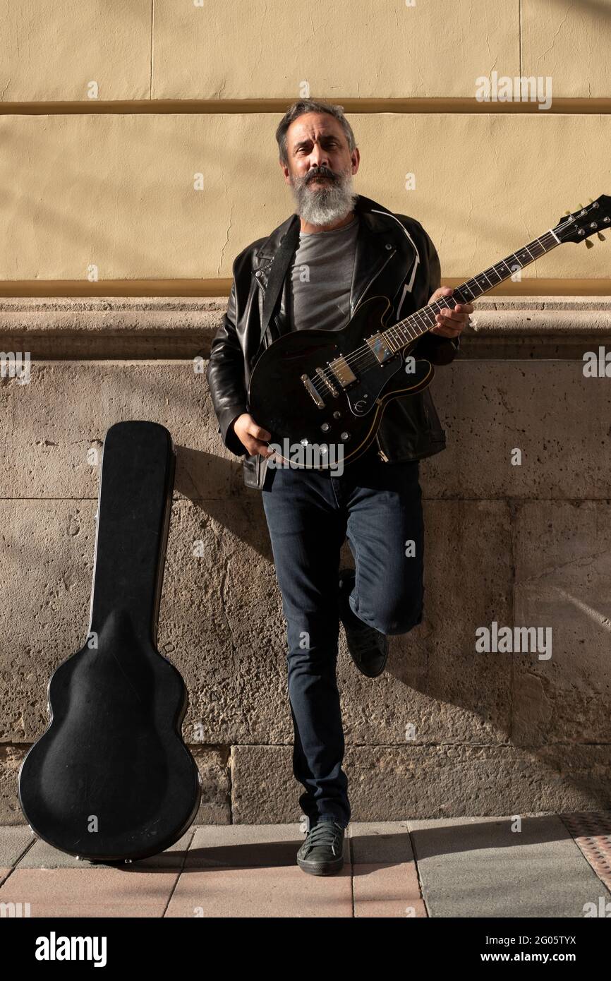 older man with beard and playing electric guitar Stock Photo