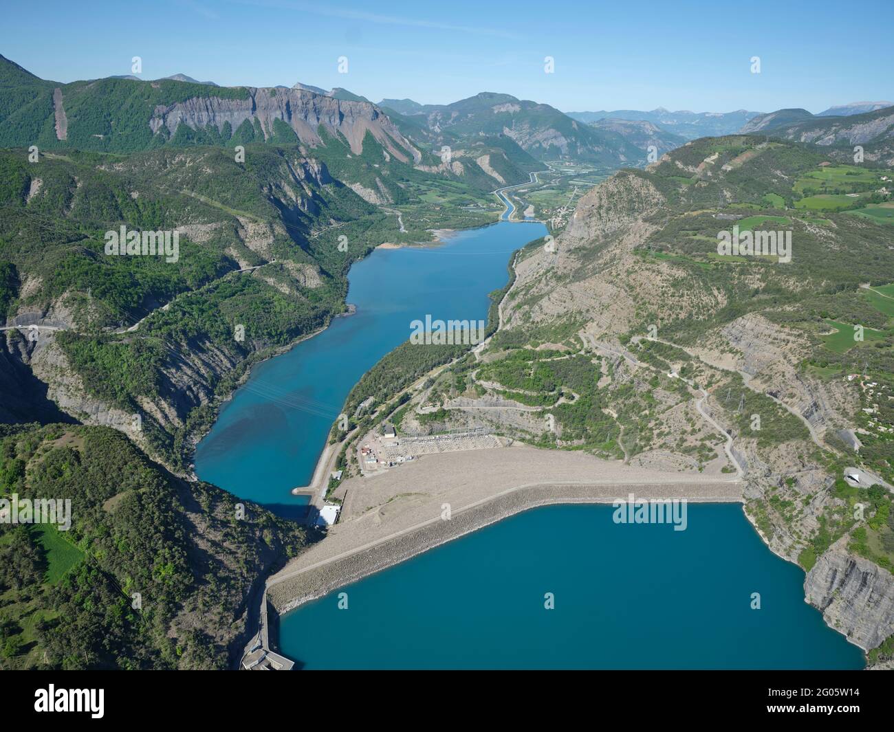 AERIAL VIEW. Dam of Lake Serre-Ponçon with the EDF canal and the Durance River in the distance. France. Stock Photo