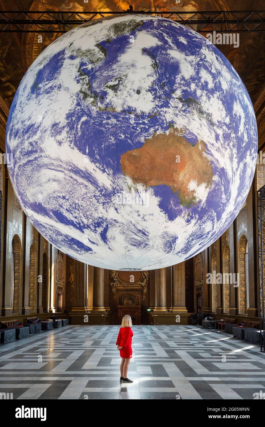 London, UK  1 June 2021.  Staff view artist Luke Jerram’s “Gaia” which has been installed in the Painted Hall at the Old Royal Naval College in Greenwich.  The scale replica of Earth rotates slowly aiming to inspire a sense of the Overview Effect that astronauts experience when they see Earth from space.  The work is on display until 1 July.  Credit: Stephen Chung / Alamy Live News Stock Photo