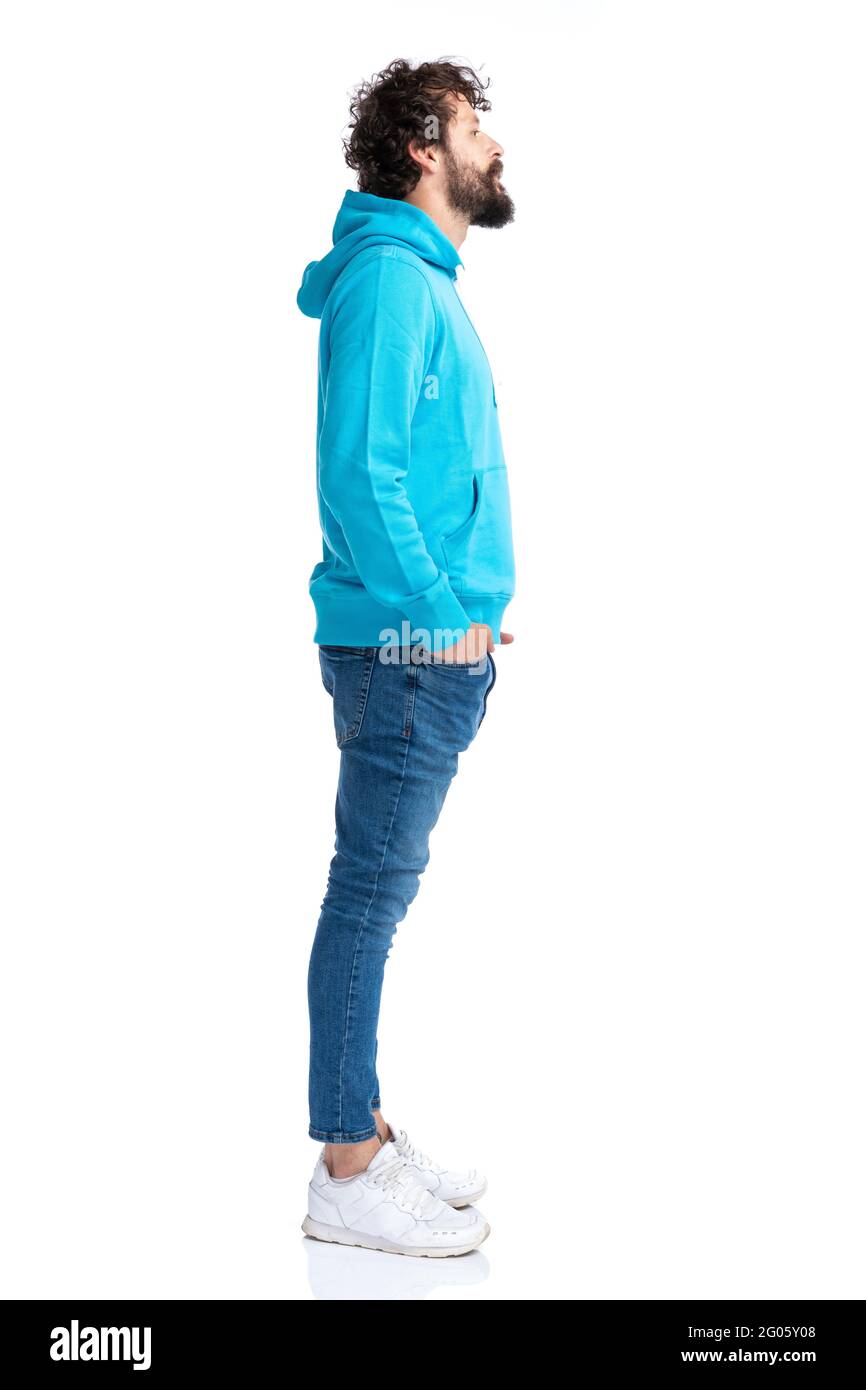 full body picture of young bearded guy in blue hoodie waiting in line while posing against white background isolated in studio Stock Photo Alamy