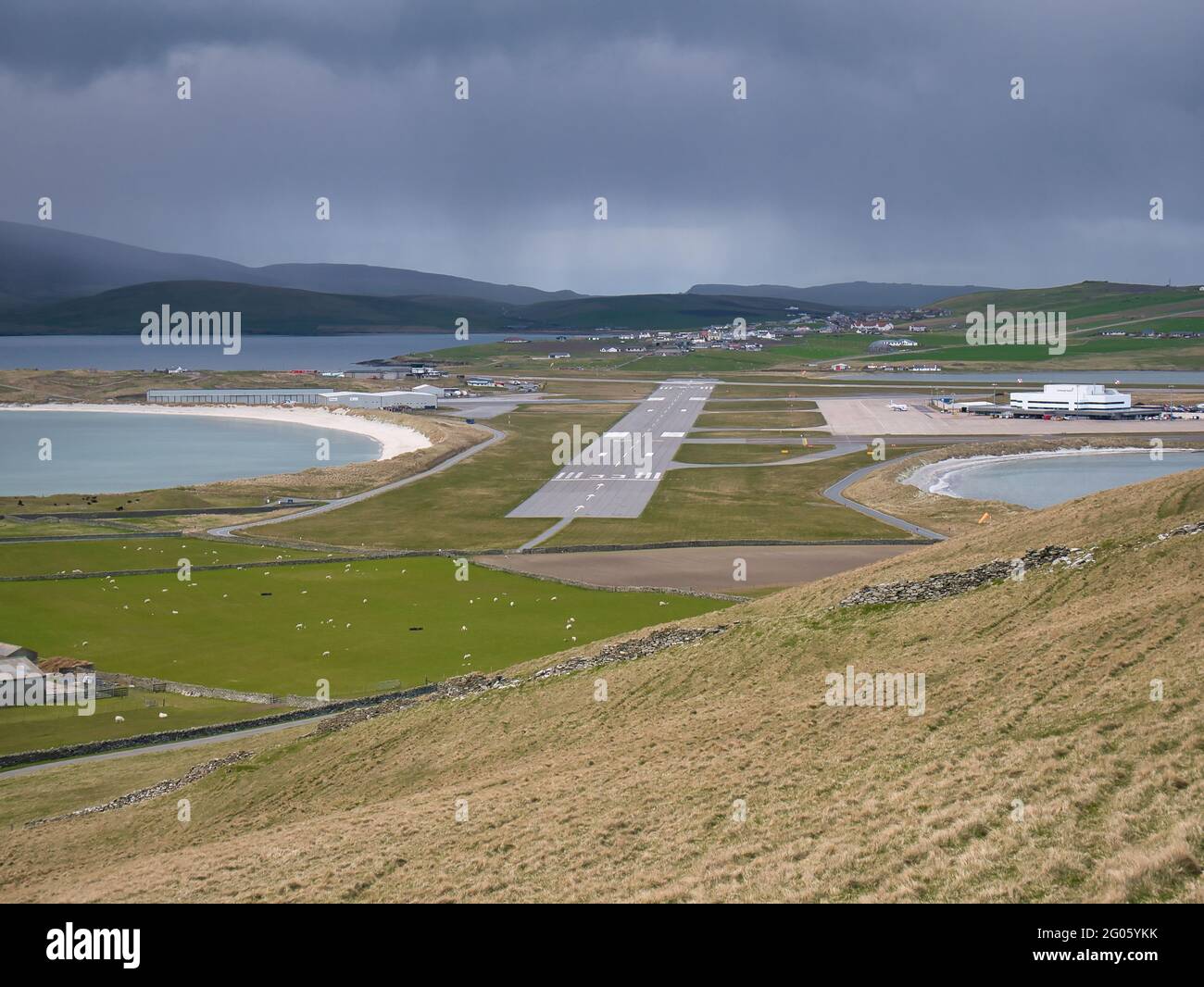On a cloudy, overcast day, a view of Sumburgh Airport runway 15-33 between two beaches in the south of Shetland in the UK. Stock Photo