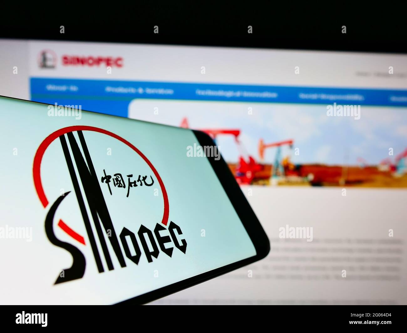 Smartphone with logo of company China Petrochemical Corporation (Sinopec) on screen in front of web page. Focus on center-right of phone display. Stock Photo