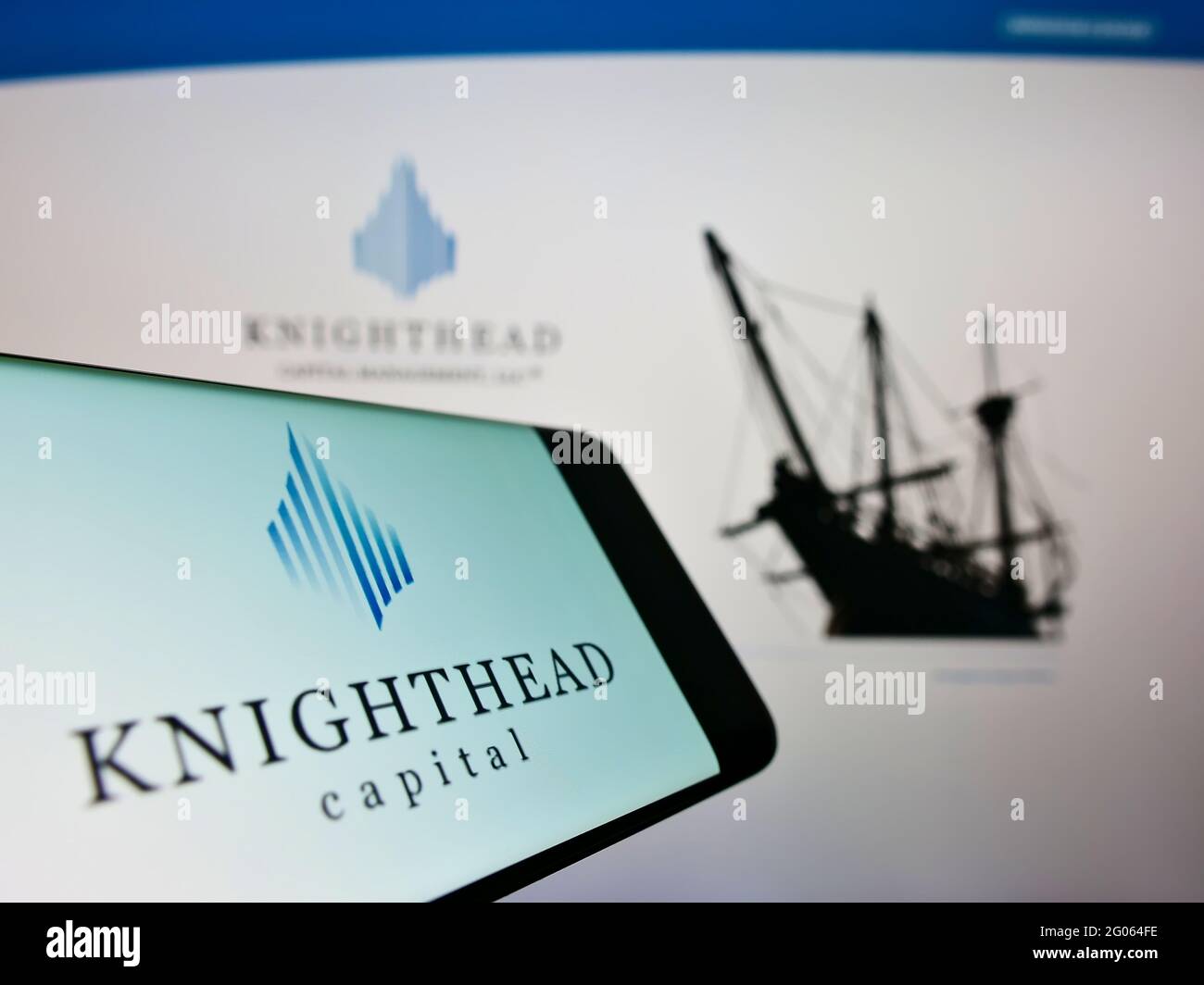 Cellphone with logo of investment adviser Knighthead Capital Management LLC on screen in front of webpage. Focus on center-right of phone display. Stock Photo