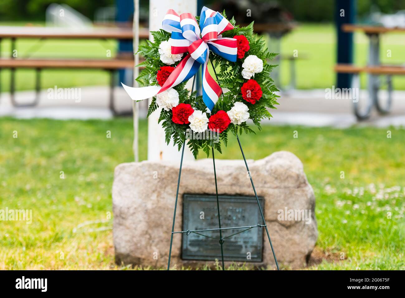 Wreath of fresh flowers placed in front of a war memorial during the ...