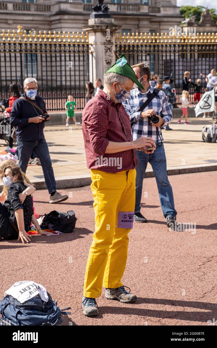LONDON, UK - Climate activist wears bright and colorful clothes with yellow trousers during an Extinction Rebellion demonstration by Buckingham Palace Stock Photo