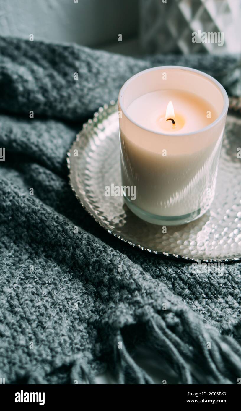 White burning candle in glass candleholder on vintage metal tray, warm cozy  home Stock Photo - Alamy