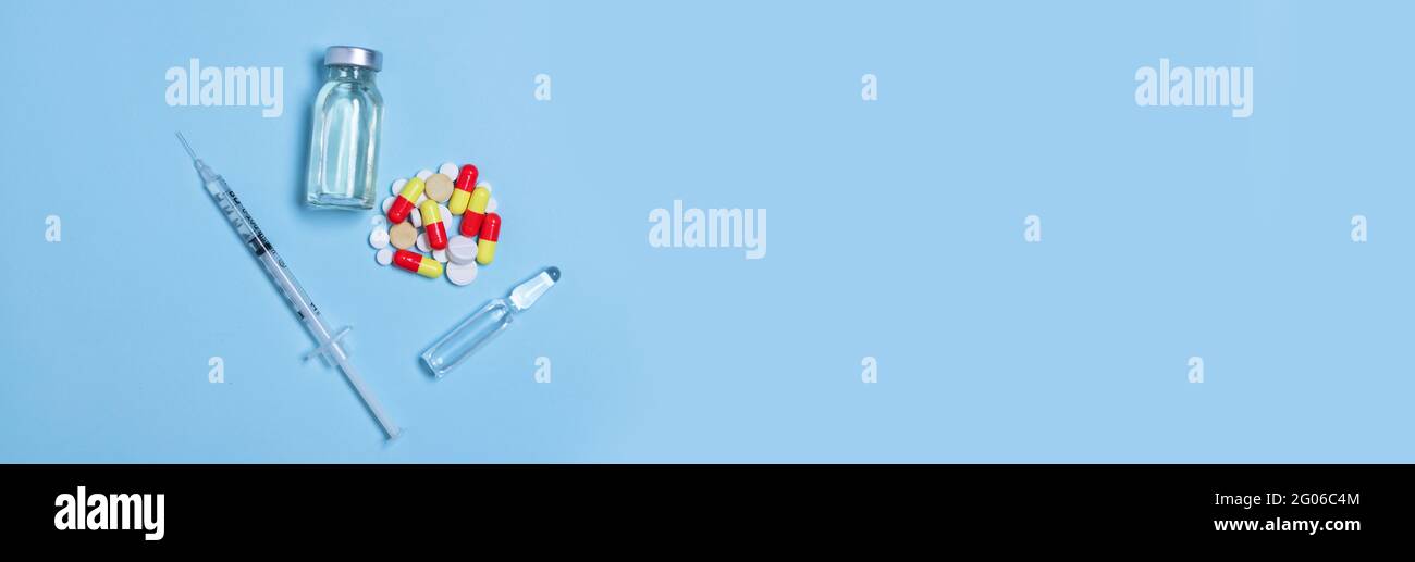 Syringe and vaccine or medicine vial on a blue background with copy ...