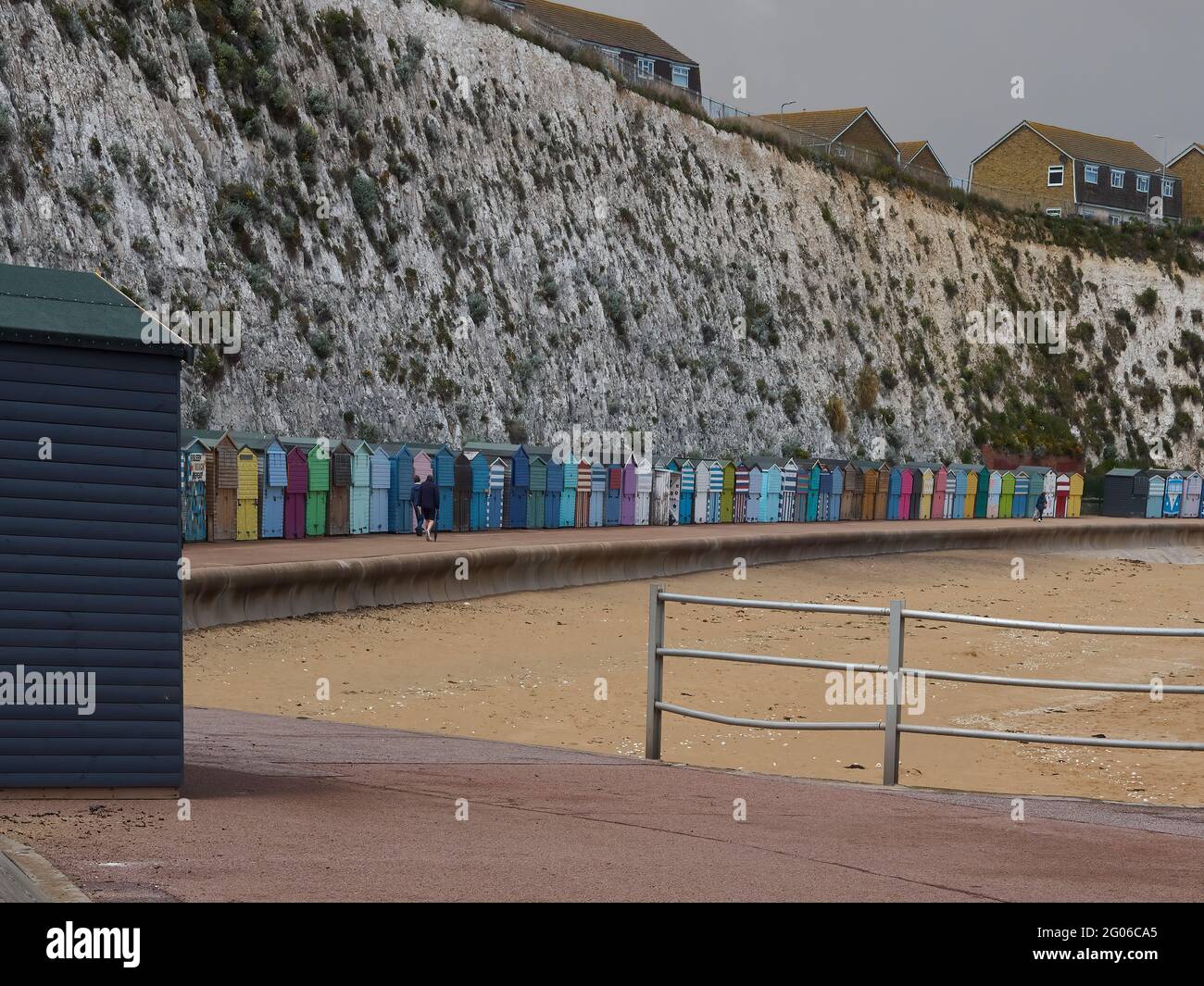 Stone Bay’s sweeping curve, with its cliffs, beach huts and golden sands, with a small group of unrecognisable people walking along the path. Stock Photo