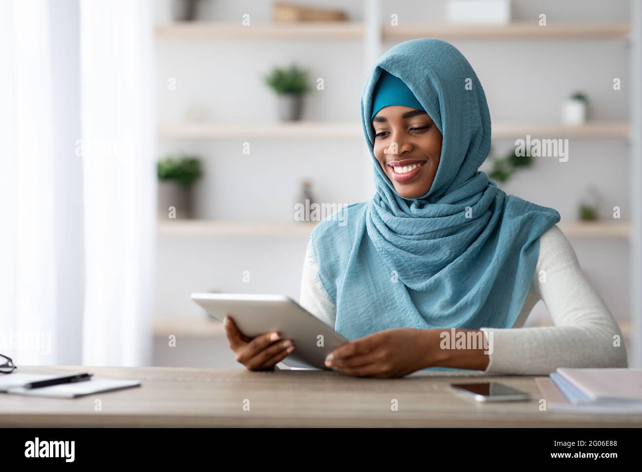 Young Black Muslim Lady In Hijab Using Digital Tablet At Home Office ...