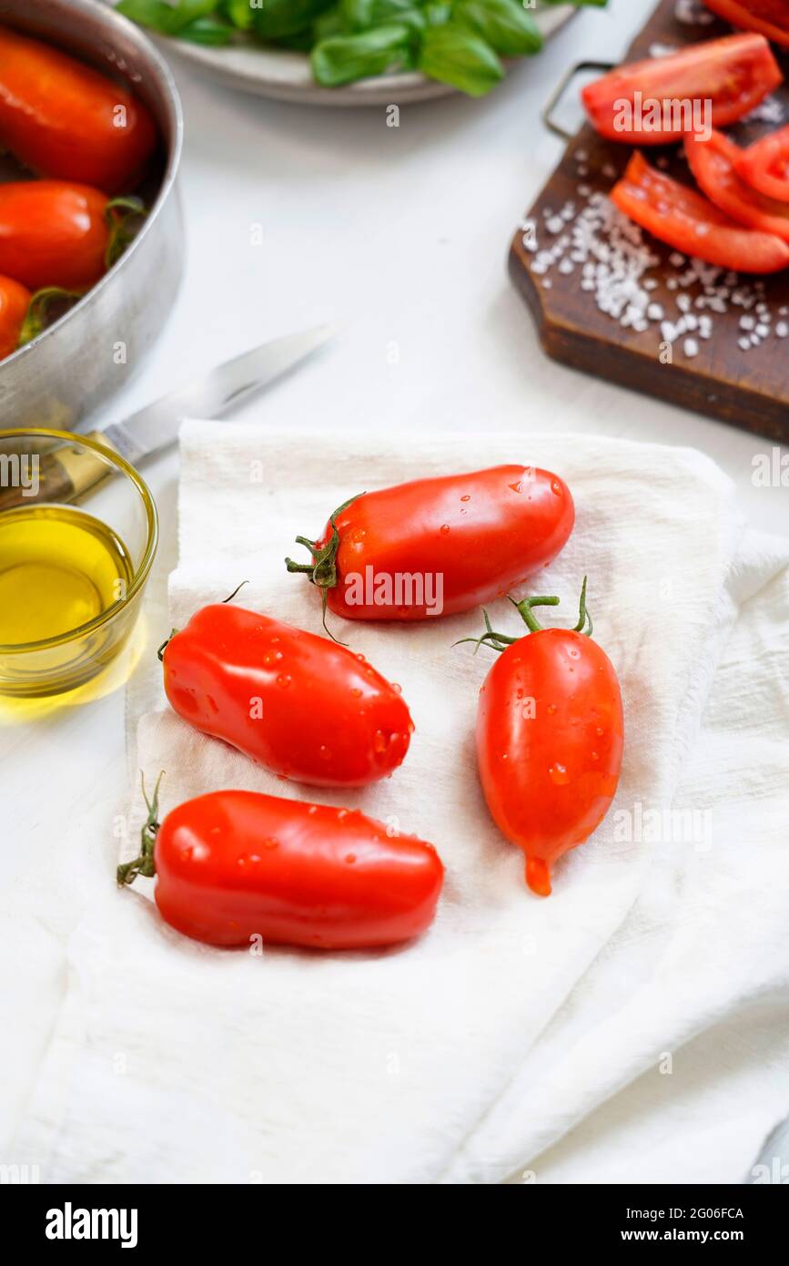 Ingredients for the preparation of  Salsa al Pomodoro or Passata di pomodoro, tomato perini, basil, salt and olive oil, traditional tomato sauce condi Stock Photo