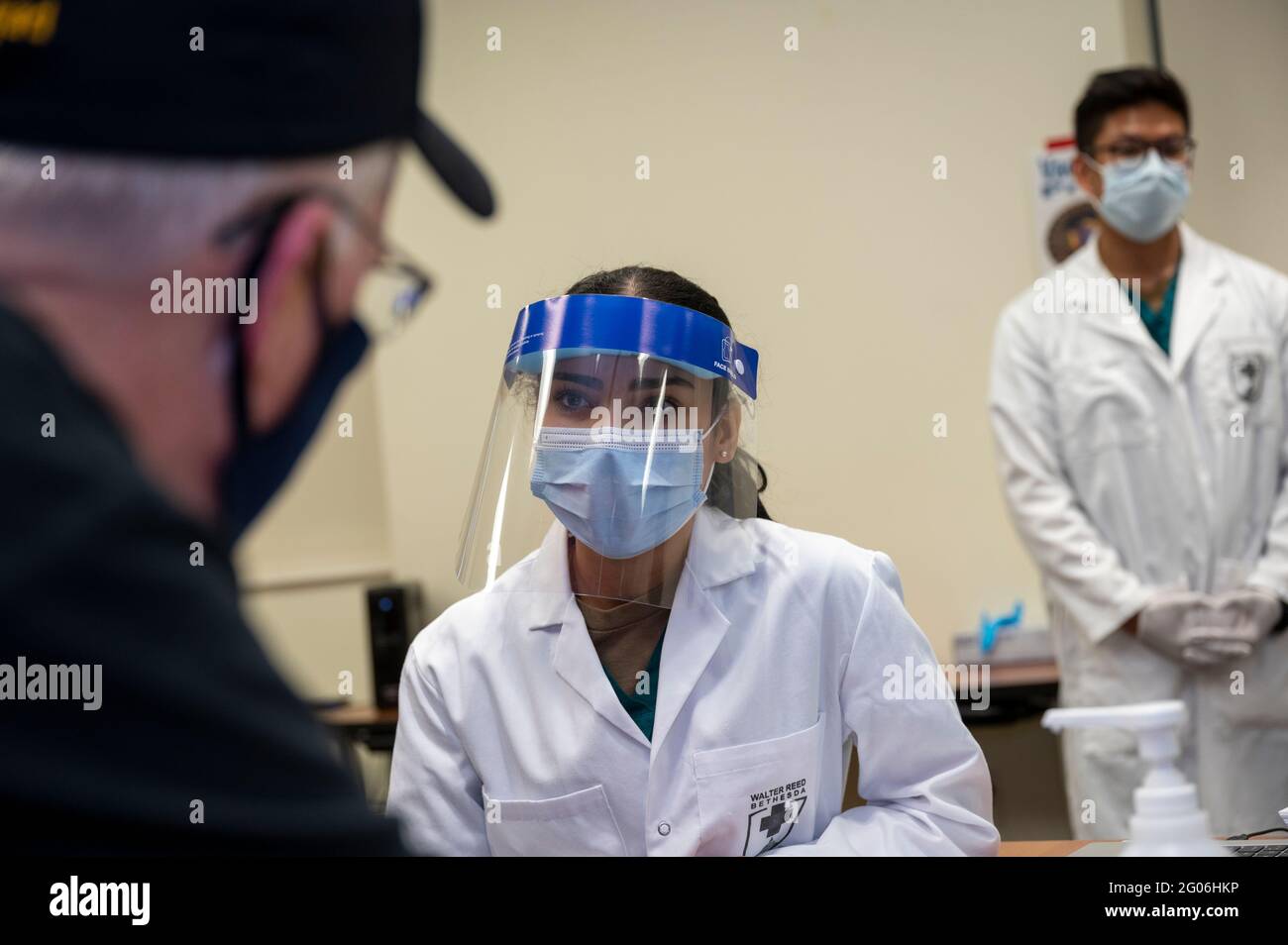 Reportage:  Acting Defense Secretary Chris Miller talks with Navy Hospitalman Samantha Alvarez, after she administered a COVID-19 vaccine to him, Walter Reed National Military Medical Center, Bethesda, Md., Dec. 14, 2020. Stock Photo
