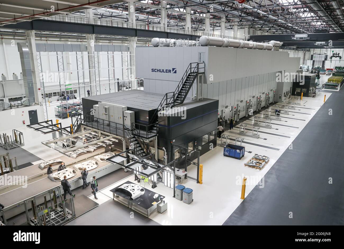 01 June 2021, Saxony-Anhalt, Halle: Employees produce engine hoods for the  Porsche Macan on the new six-stage servo press line at the joint press shop  of Porsche and Schuler. The new body
