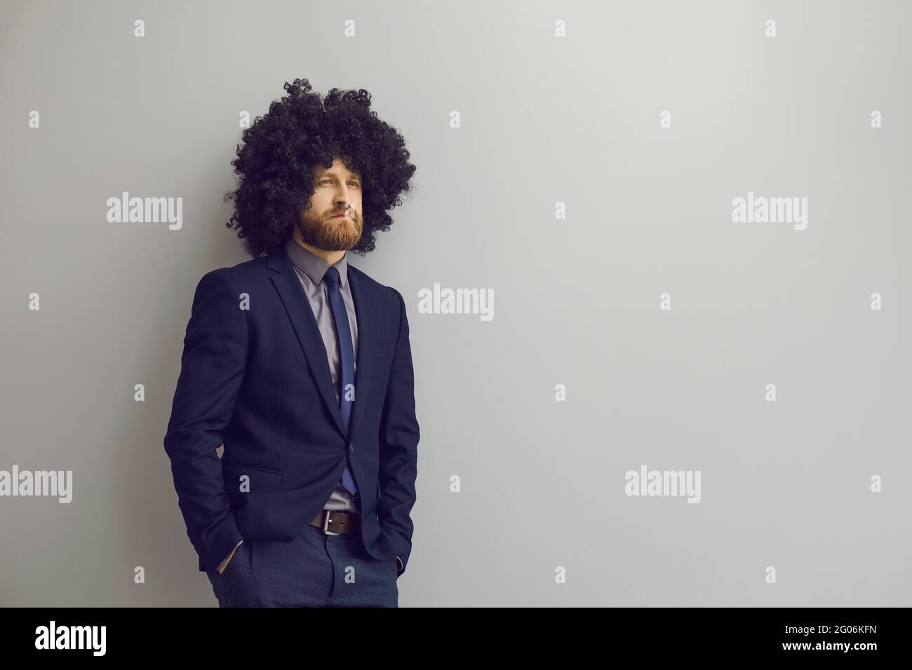 Businessman with funny hair looking away and thinking standing on gray copy space background Stock Photo