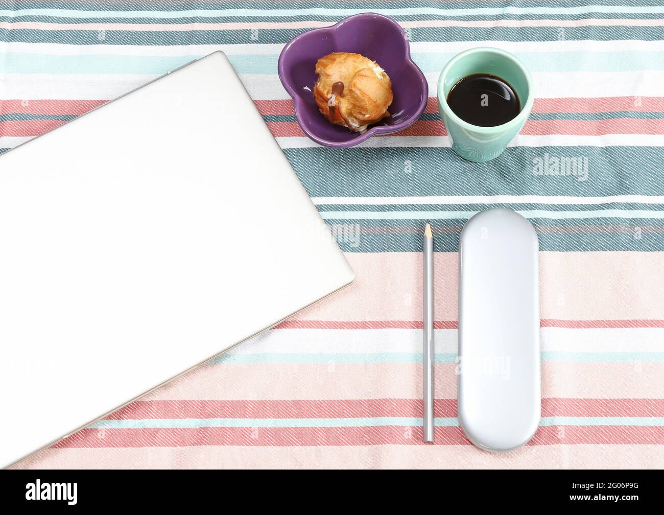 Modern home office or work place with laptop, pencil, coffee and sweets Stock Photo