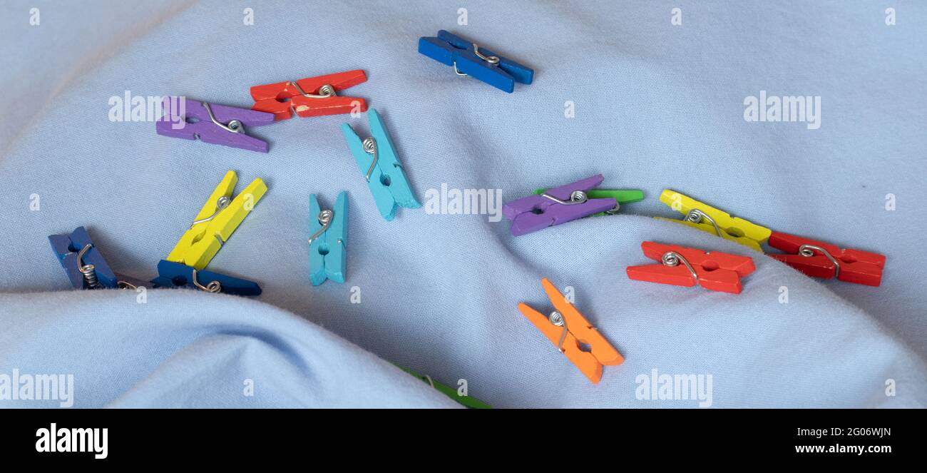 Clothespins scattered on a blue cloth Stock Photo