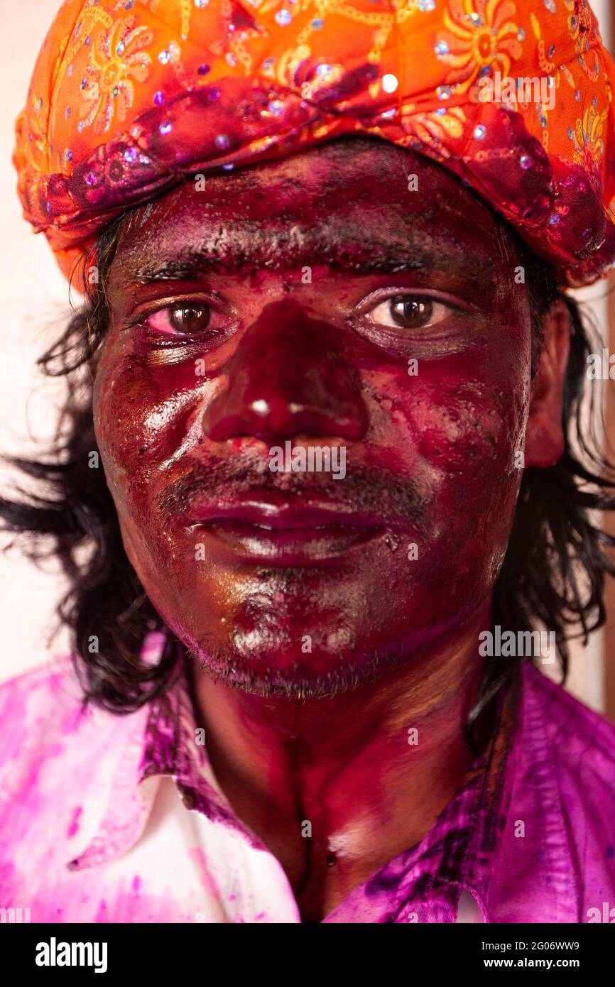 Indian man portrait with face smudged with multicolour and looking at camera Stock Photo