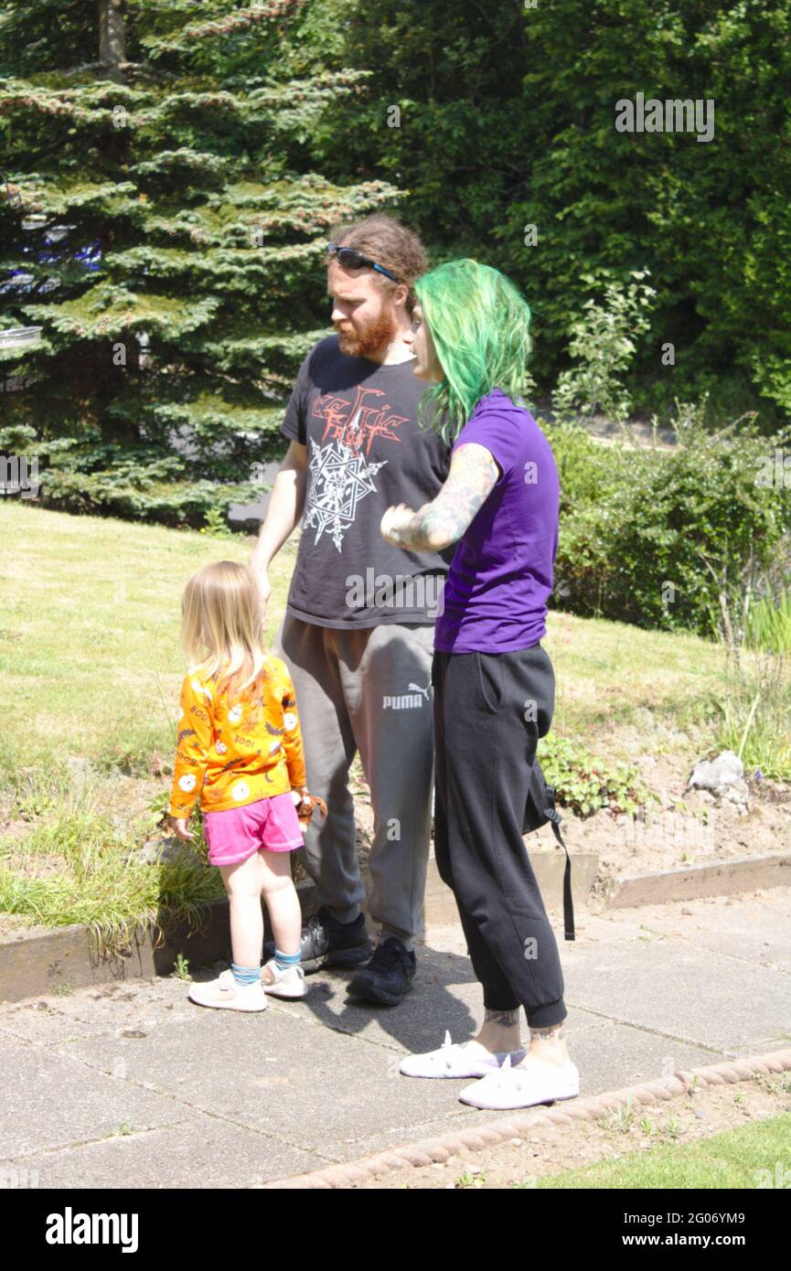 Young happy family walking outdoors. One Parent has green hair Stock Photo
