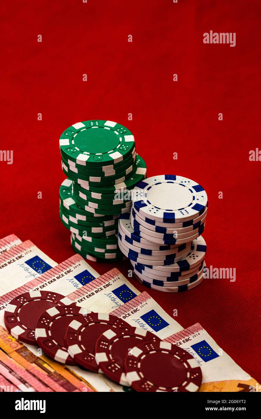Stacks of poker chips with money on red background, EURO currency ...