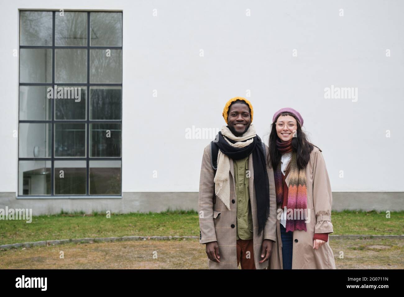 Portrait of young multiethnic couple smiling at camera while standing outdoors Stock Photo
