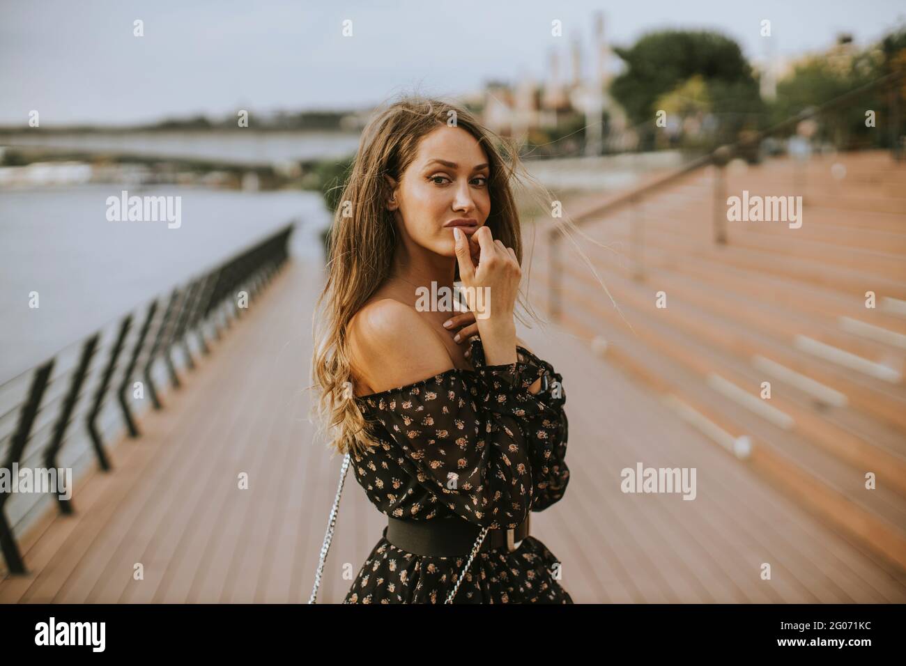 Pretty young long hair brunette woman walking on the riverside Stock ...