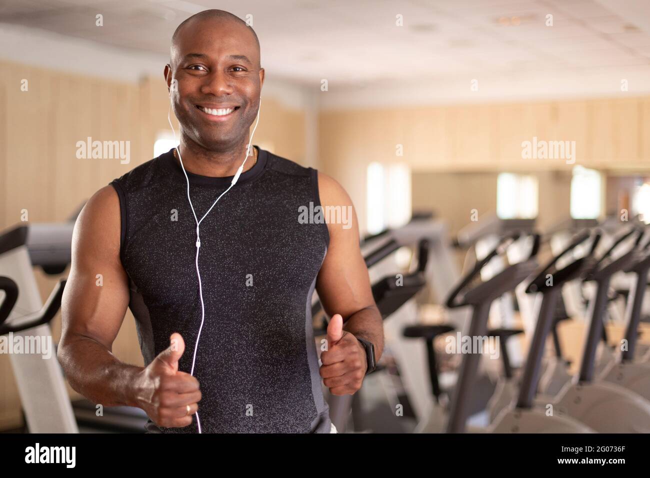 Portrait of smiling black man in fitness club. He has thumbs up in positive attitude. Concept of sport and healthy life. Stock Photo