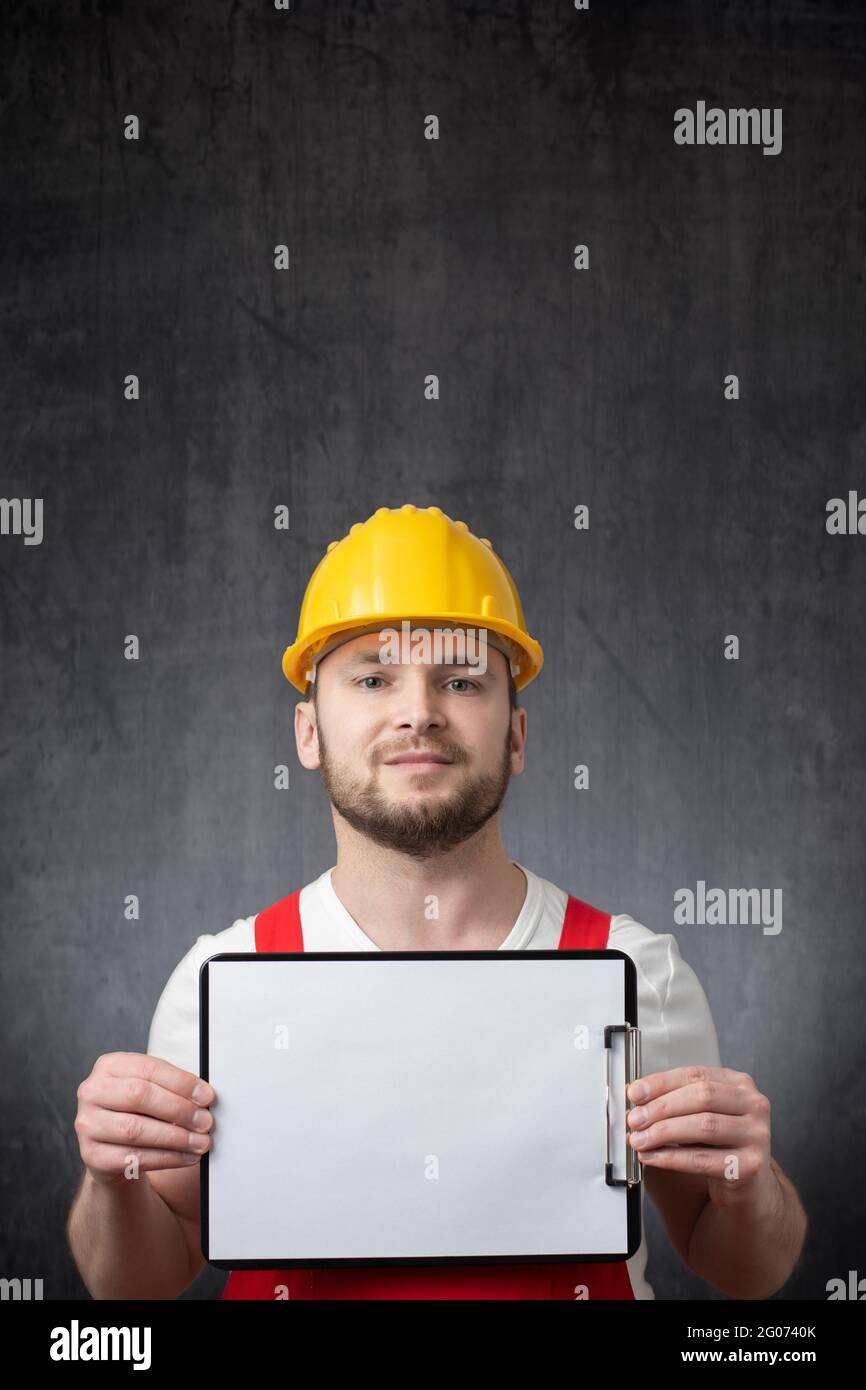 A worker showing a clipboard with blank paper Stock Photo