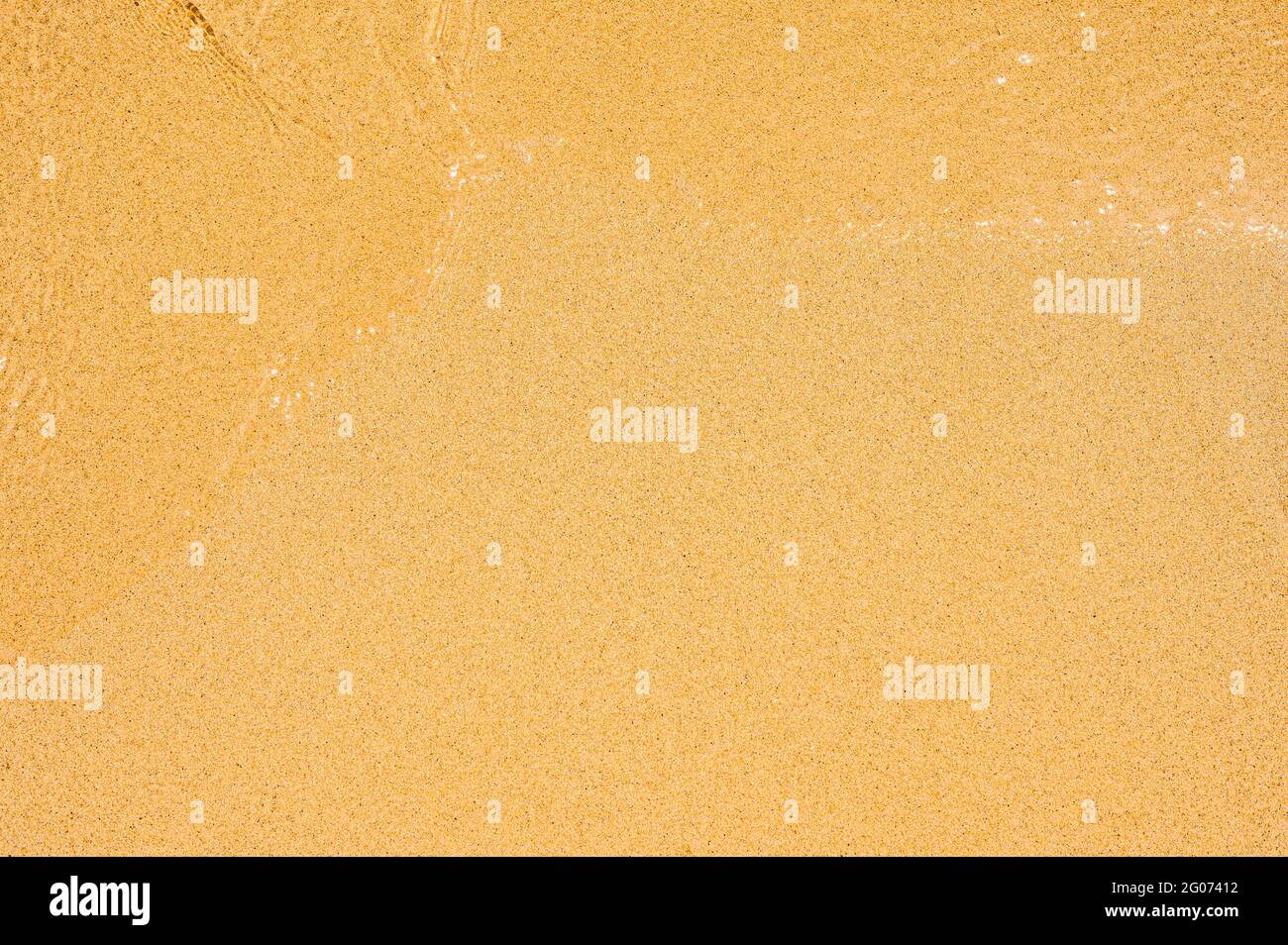 Closeup Of Wet Sand Texture Pattern On The Beach. Wave on clear sand beach. beach sand perfect plain texture background Stock Photo