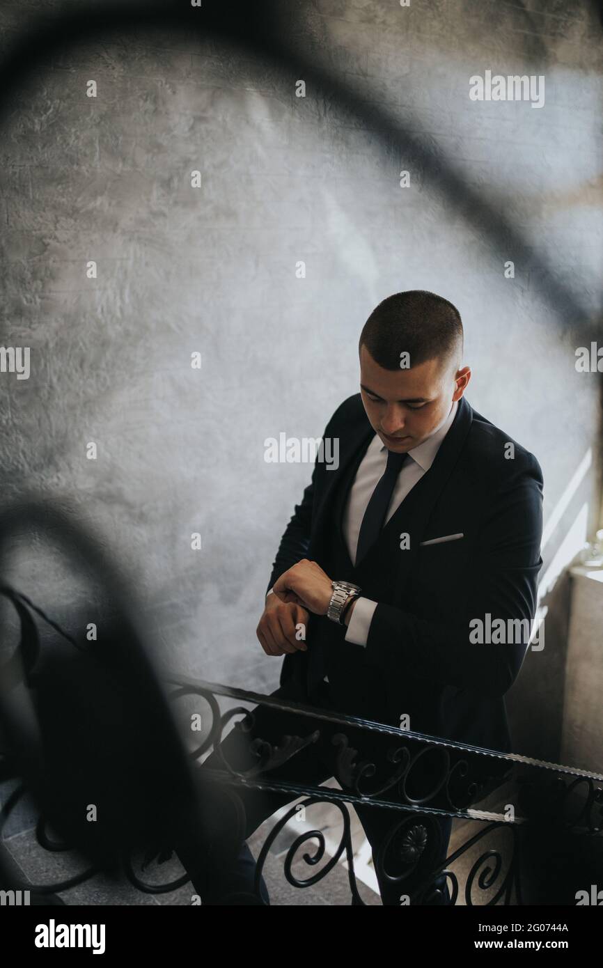 Young man in an elegant black suit with a tie on the stairs Stock Photo ...