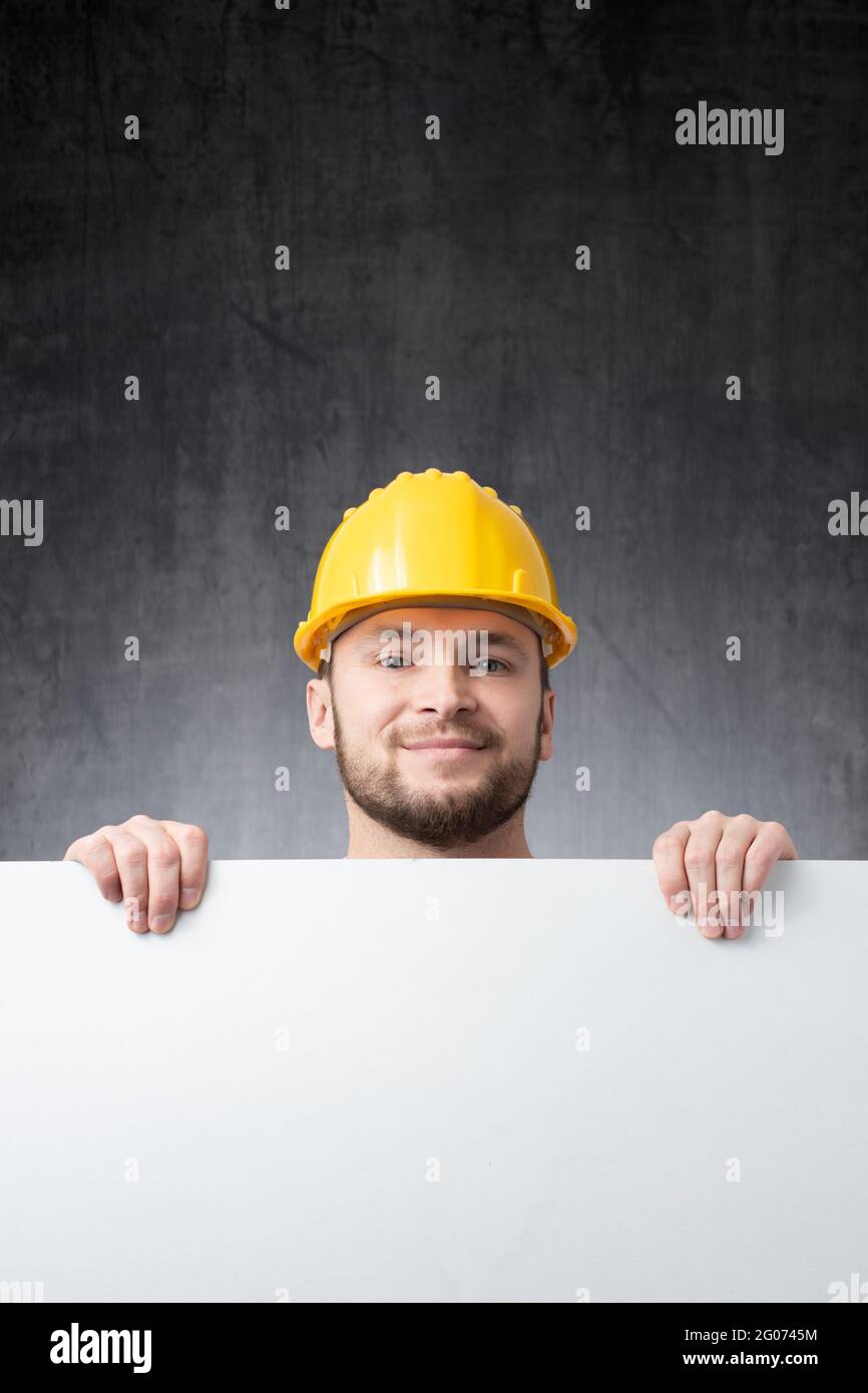 Construction worker holding a blank white board Stock Photo