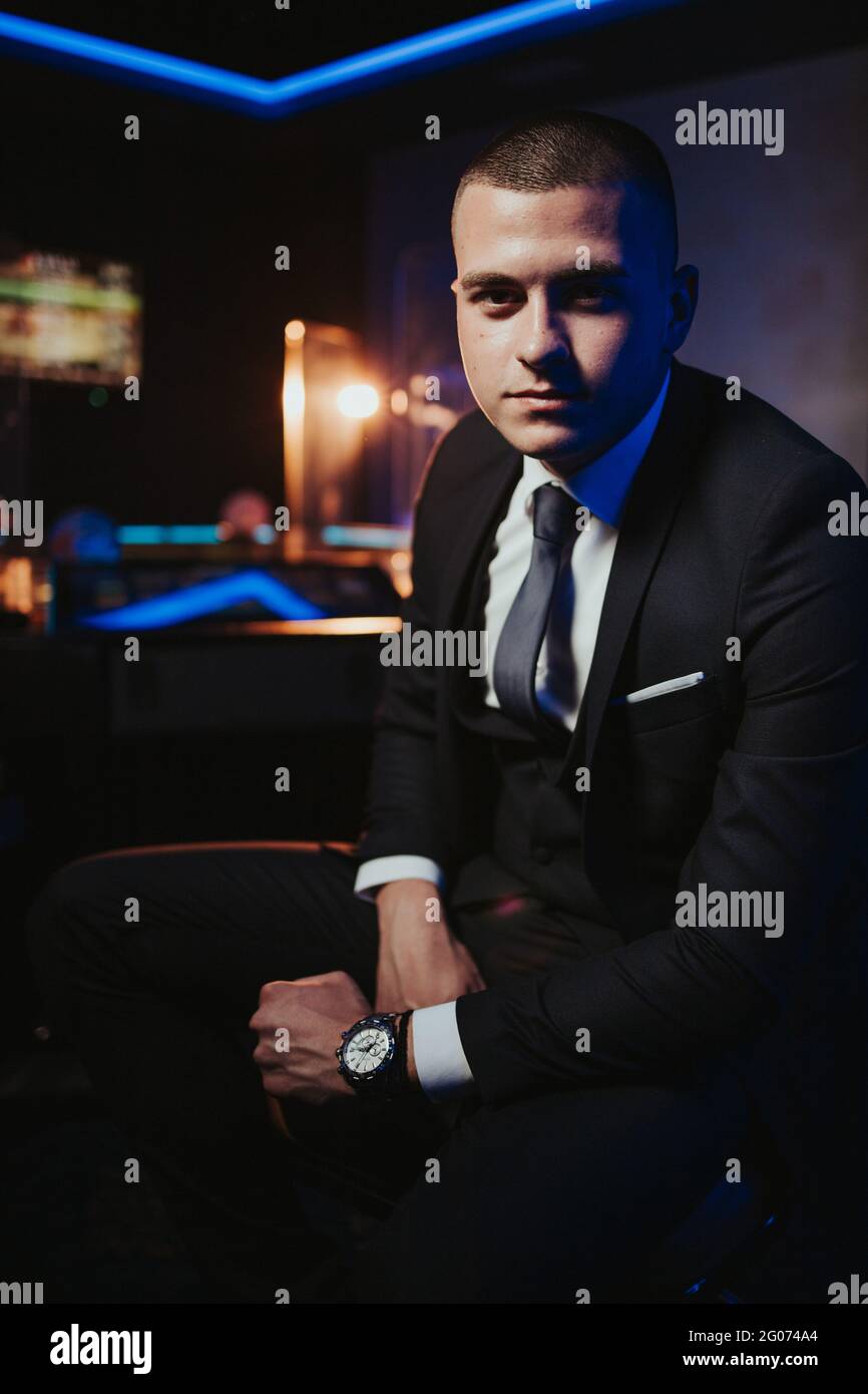 Young man in an elegant black suit with a tie and a watch posing Stock ...