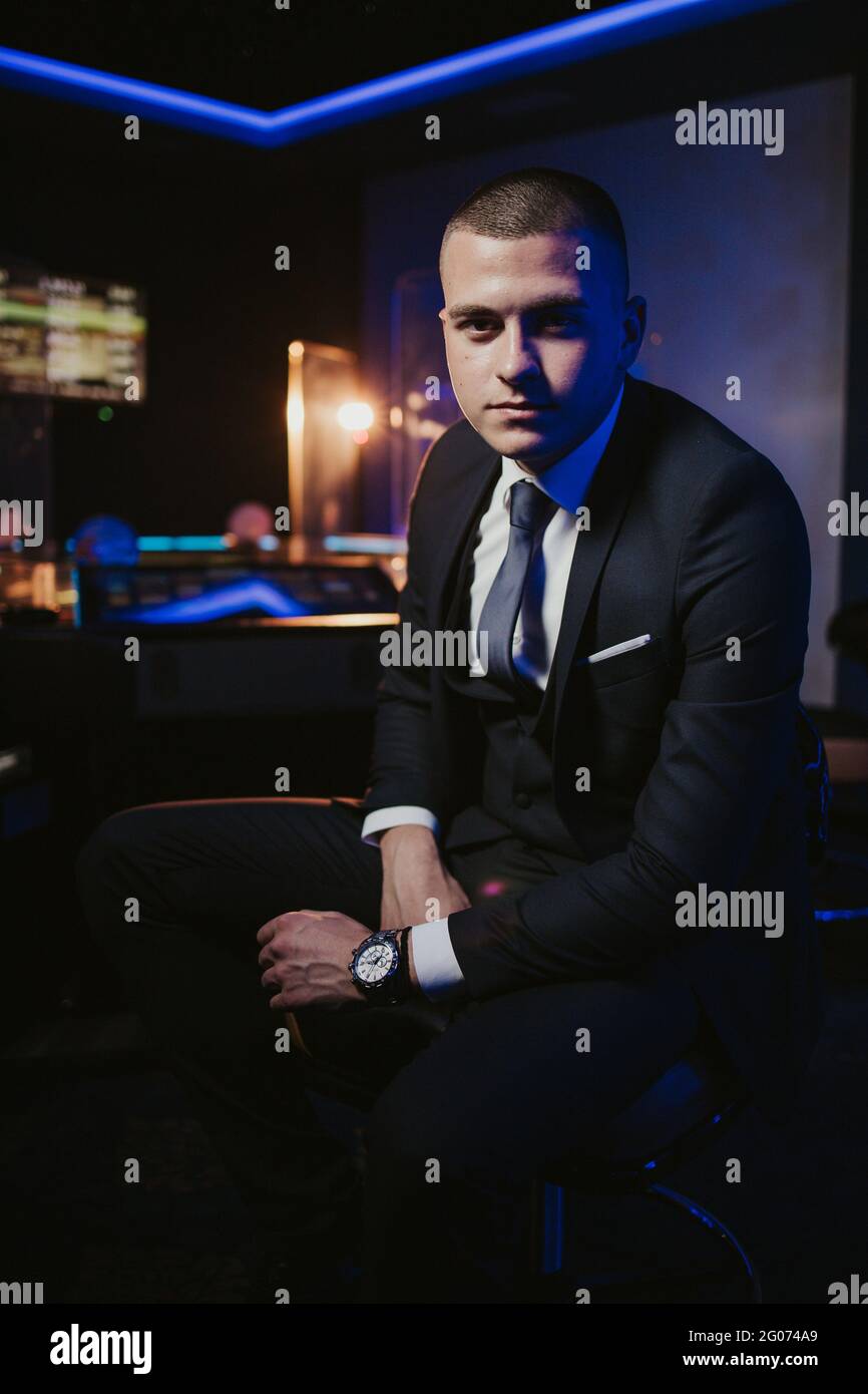 Young man in an elegant black suit with a tie posing Stock Photo - Alamy