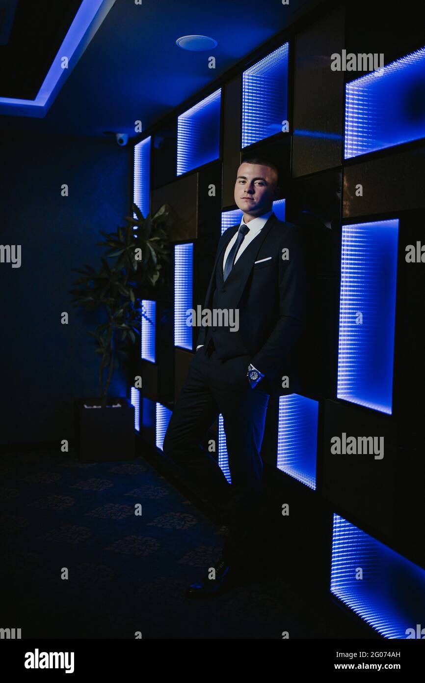 Young man in an elegant black suit with a tie posing Stock Photo - Alamy