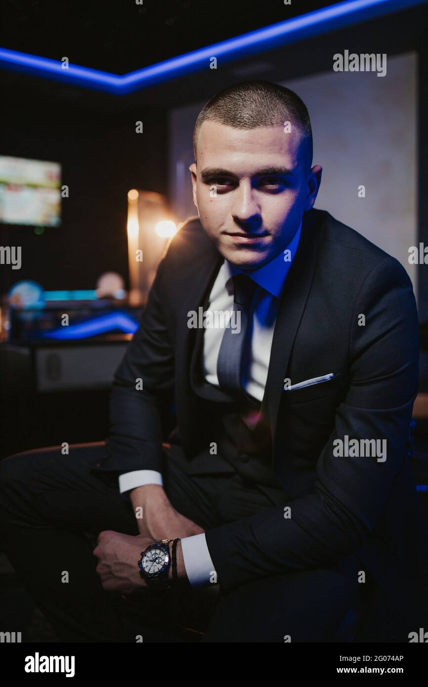 Young man in an elegant black suit with a tie and a watch posing Stock ...
