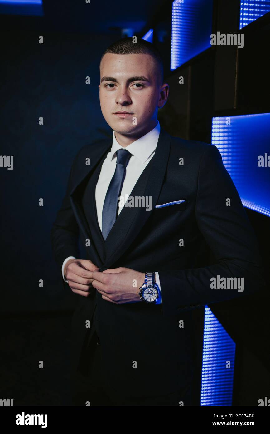 Young man in an elegant black suit with a tie and a watch posing Stock ...